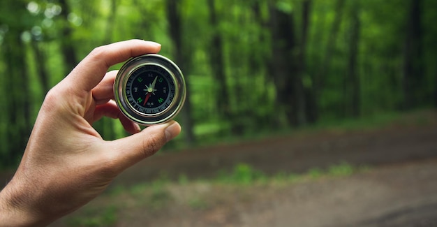 Boussole dans la main de l'homme dans la forêt