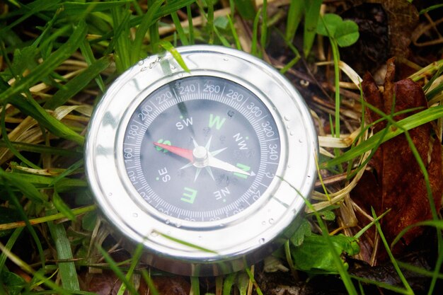 Boussole sur fond d'herbe d'été comme symbole du tourisme