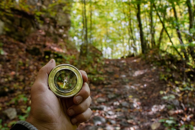 Boussole à la main dans la forêt d'automne