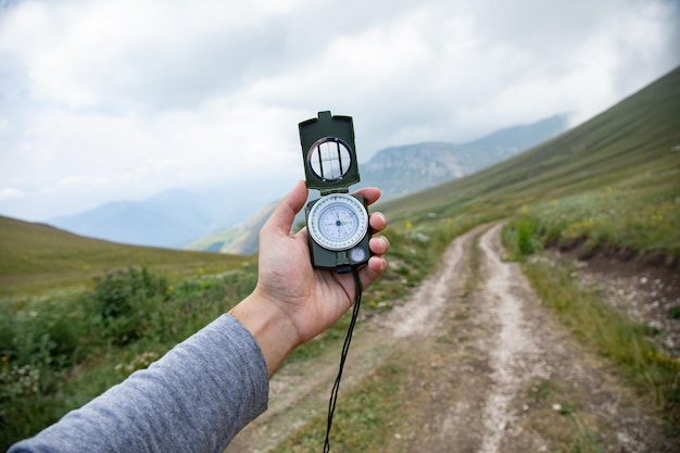 Boussole de main d'homme dans la route de montagne