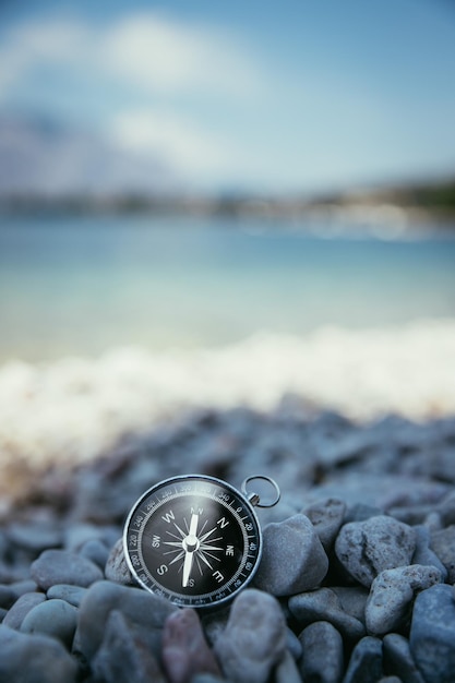 Boussole sur la plage espace de texte de petites pierres