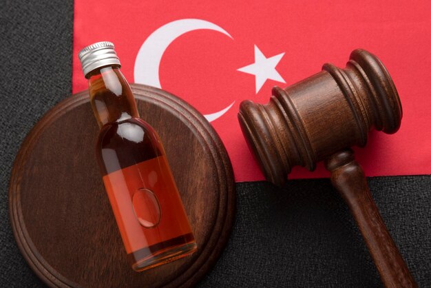 Bouteille d'alcool et marteau en bois comme symbole de la loi sur fond de drapeau turc Vue de dessus gros plan Législation sur l'alcool en Turquie