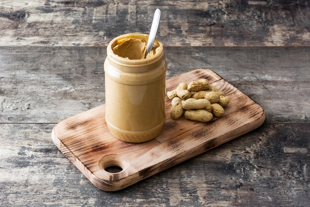 Bouteille de beurre d'arachide crémeux sur table en bois