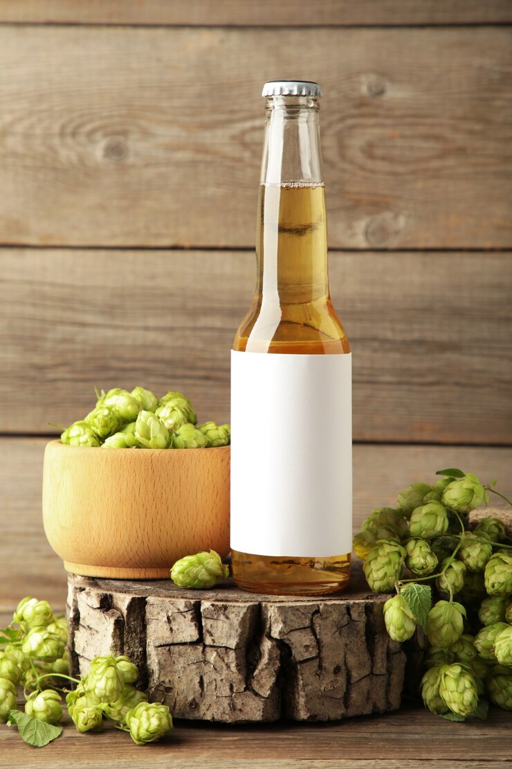 Bouteille de bière avec des cônes de houblon sur fond gris, gros plan. Photo verticale