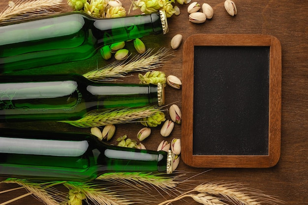 Une bouteille de bière avec des épillets de blé d'avoine de houblon vert et des verres avec de la bière sombre et claire sur un tableau noir rayé Vue de dessus