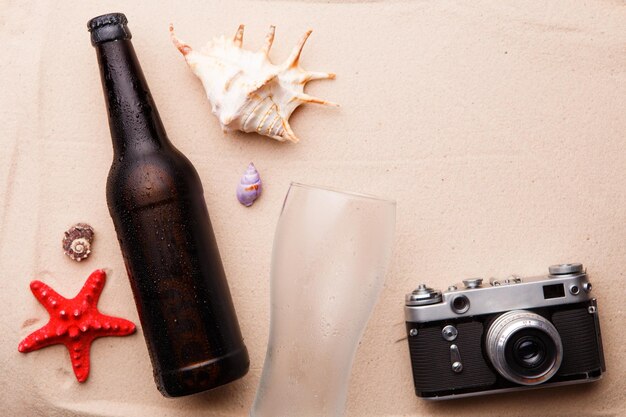 Bouteille de bière et verre sur une plage de sable