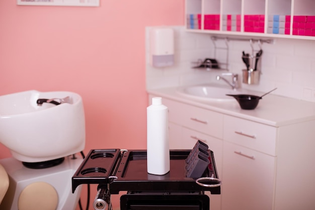 Bouteille blanche avec shampooing capillaire dans un salon de coiffure