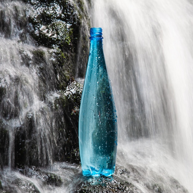 Bouteille bleue d'eau minérale dans la nature