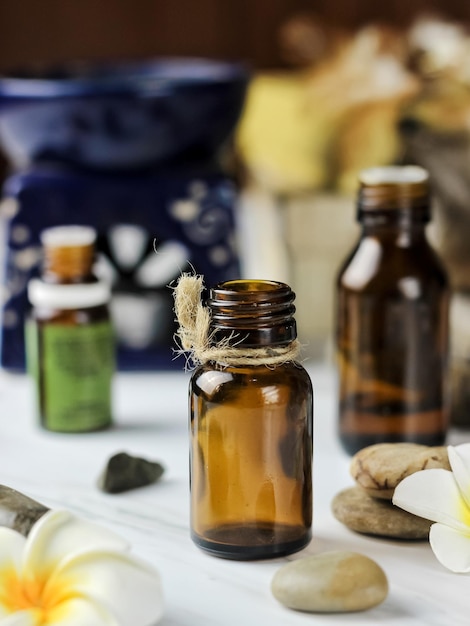 Bouteille brune vide avec pierre et fleur de frangipanier. Mise au point sélective