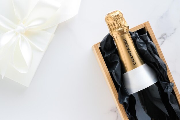 Une bouteille de champagne et un coffret cadeau sur marbre