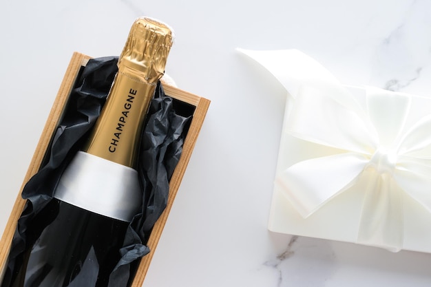 Photo une bouteille de champagne et un coffret cadeau sur marbre