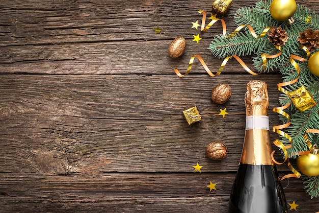 Bouteille de champagne avec des décorations de Noël sur bois