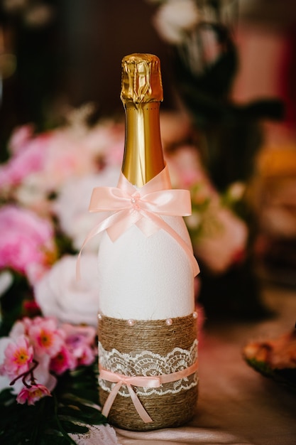 Photo bouteille de champagne mariée et le marié sur la table de fête les jeunes mariés.