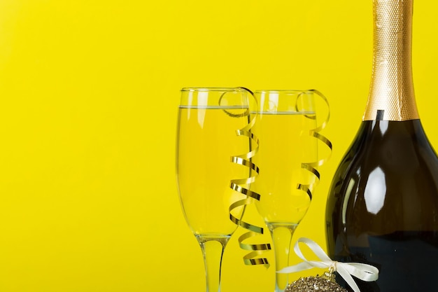 Photo bouteille de champagne avec verres à confettis et décor de noël sur fond de vacances coloré décorations de nouvel an à plat