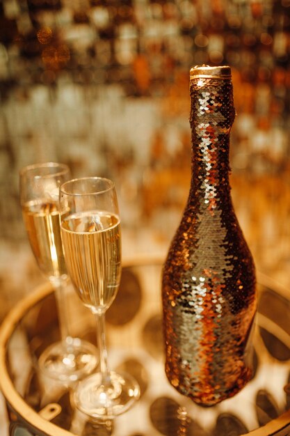 Bouteille de champagne et verres contre lueur de luxe décoration de pluie dorée fête de vacances chère