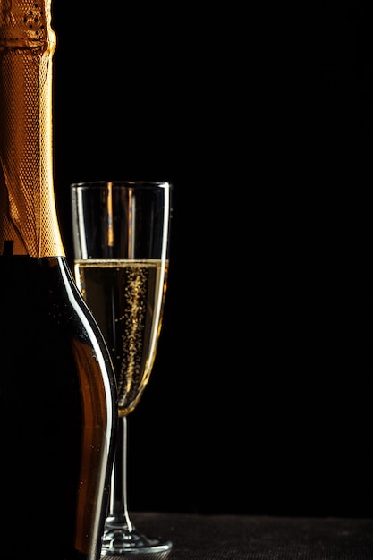 Bouteille de champagne et de verres sur fond sombre
