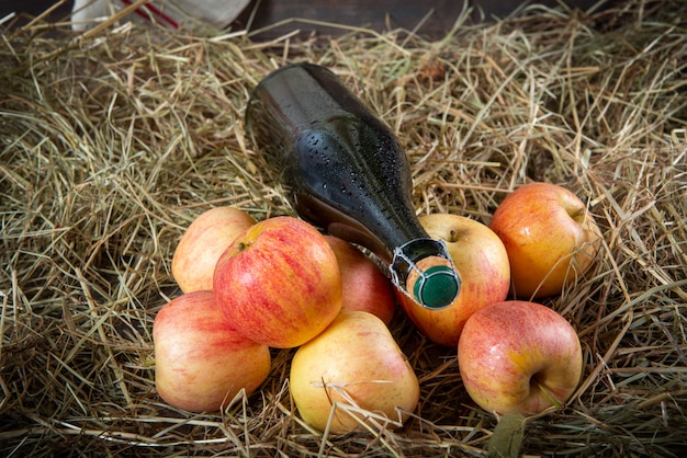 Bouteille de cidre aux pommes sur la paille