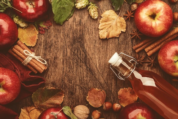 Bouteille de cidre de pomme avec des bâtons de cannelle, des clous de girofle et de l'anis sur fond de bois Boisson traditionnelle d'automne et d'hiver et cocktail Vue de dessus