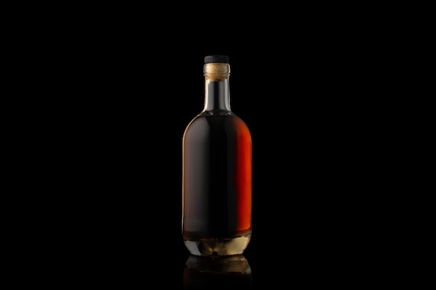 Bouteille de cognac isolée sur fond noir.