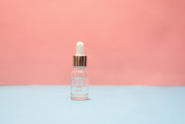 Une bouteille cosmétique sur le fond rose et bleu