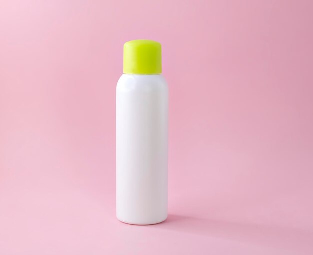 Une bouteille cosmétique en plastique blanc vierge pour shampooing, lotion, crème ou autre produit cosmétique sur rose