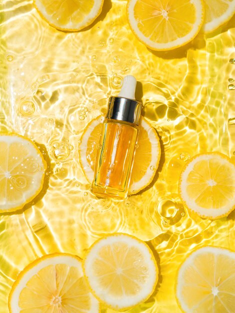 Bouteille de cosmétiques dans l'eau tranches de citron jaune