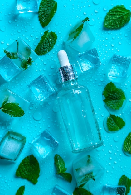 Bouteille avec des cosmétiques sur fond de menthe avec des glaçons et du citron Mise au point sélective