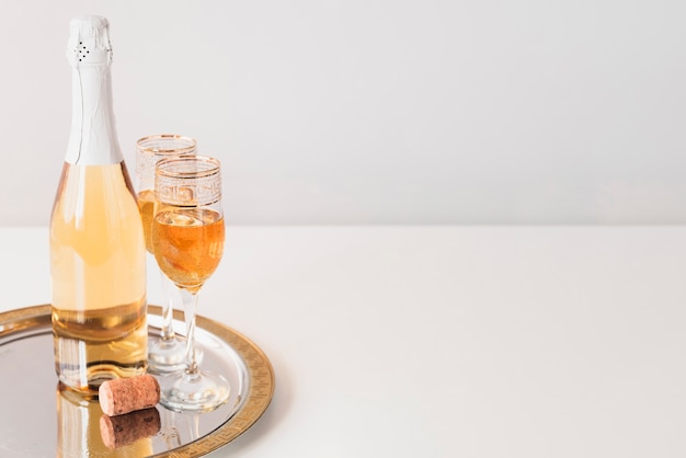 Photo bouteille avec des coupes à champagne sur un plateau