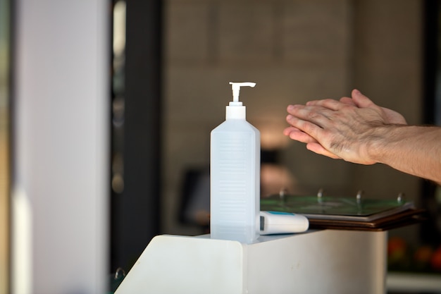 Bouteille de désinfectant pour les mains antibactérien à l'entrée du bâtiment pour les personnes qui se lavent les mains pour arrêter de propager l'épidémie de coronavirus