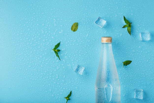 Bouteille d'eau avec des glaçons et des feuilles de menthe