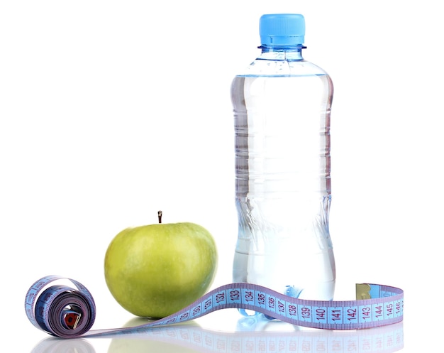 Bouteille d'eau pomme et ruban à mesurer isolé sur blanc