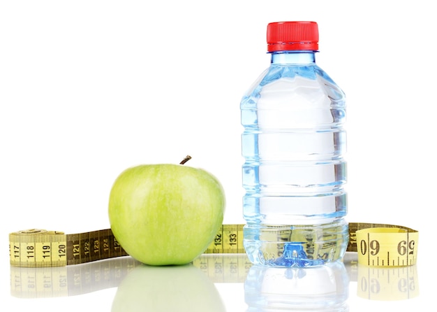 Bouteille d'eau pomme et ruban à mesurer isolé sur blanc