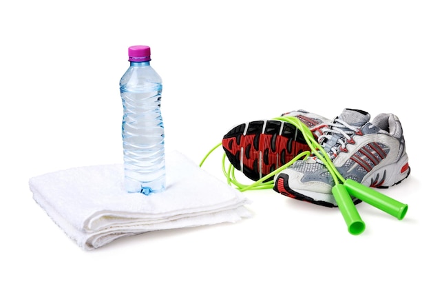 Bouteille d'eau sur serviette, corde à sauter et chaussures de sport