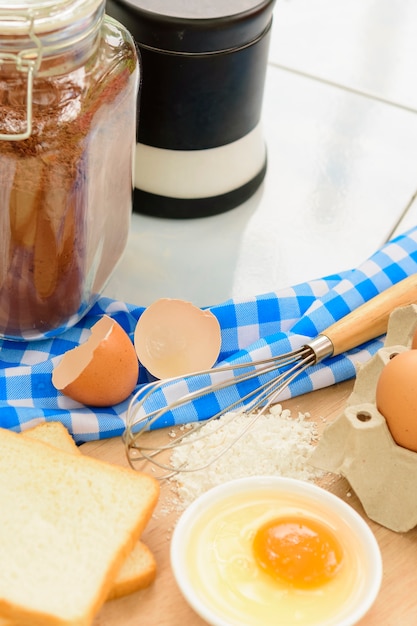 Photo bouteille de farine de blé et oeuf et oeuf sur table bleue.