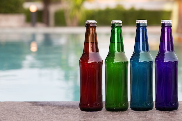 bouteille d&#39;herbe verte de liquide sur le bord de la piscine