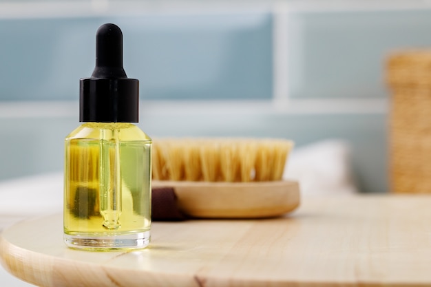 Bouteille d'huile cosmétique jaune sur plateau en bois photo en gros