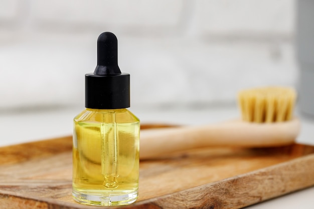 Bouteille d'huile cosmétique jaune sur plateau en bois photo en gros