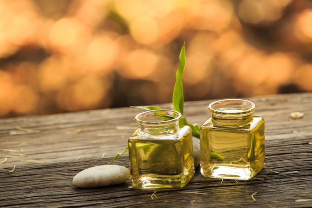 Bouteille d&#39;huile essentielle aromatique ou spa et vert naturel laisser sur une table en bois