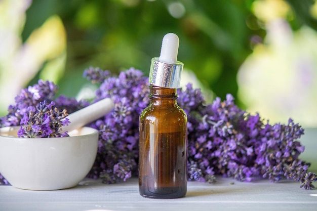 Une bouteille d'huile essentielle avec des brindilles de lavande en fleurs fraîches