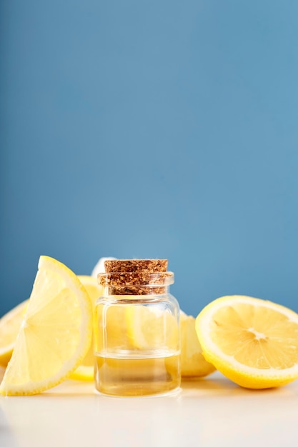 Bouteille avec de l'huile essentielle de citron avec des tranches de citron sur la table Huile ou sérum d'agrumes cosmétiques Concept de médecine naturelle Aromathérapie