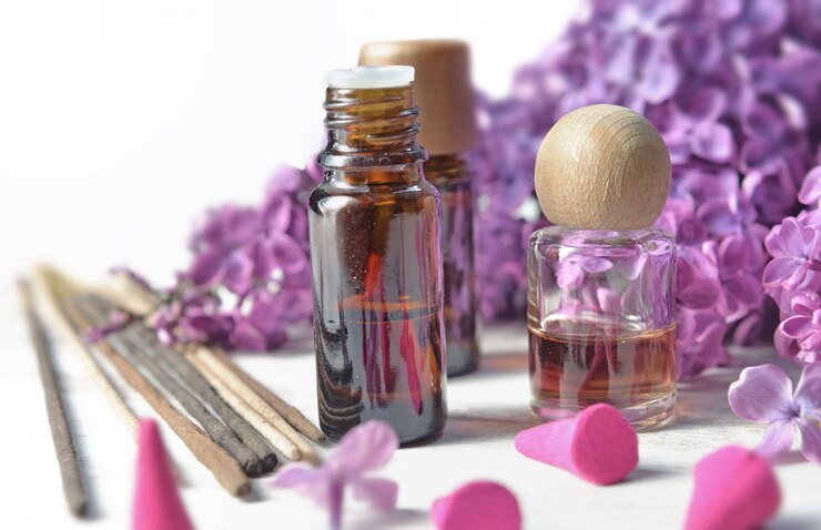 Photo bouteille d'huile essentielle et d'encens avec fleur de lilas pourpre