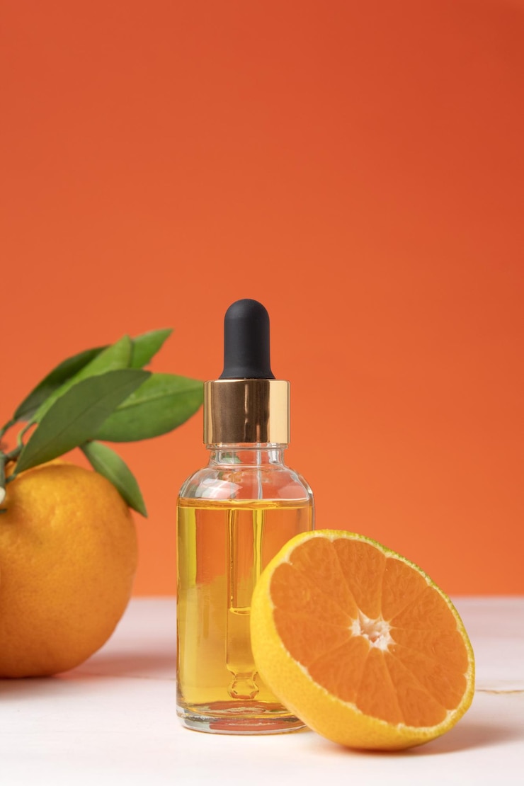 Bouteille d'huile essentielle d'orange pour l'aromathérapie Huile essentielle d'orange Huile essentielle d'agrumes sur fond de fruits