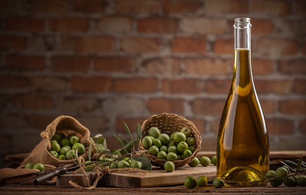 Bouteille d'huile d'olive extra vierge sur une table avec fond de mur en béton