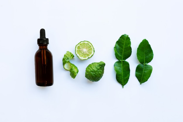 Bouteille d&#39;huiles essentielles et de fruits de Bergamot Fesh avec feuilles isolé sur blanc