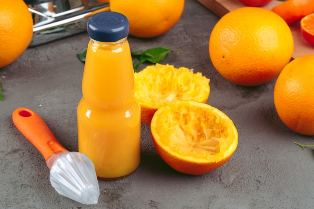 Bouteille de jus d'orange avec des oranges sur une table en bois