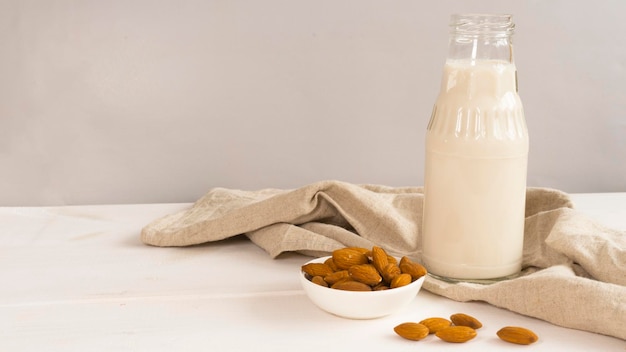 Bouteille de lait d'amande et tasse d'amandes à côté