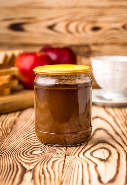 Bouteille de lait concentré sur une table en bois avec fond de toasts et tasse de thé