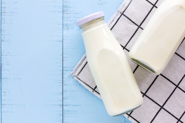 Une bouteille de lait sur un fond en bois bleu.