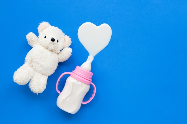 Bouteille de lait pour bébé avec jouet ours blanc sur bleu