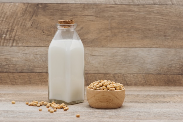 Bouteille de lait de soja et de soja sur table en bois